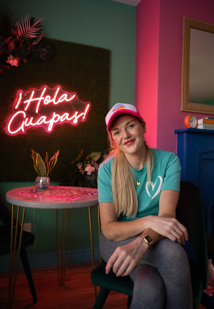 Lisa, owner of Spangles Beach, sitting at the dining table inside her colourful holiday accommodation in Portstewart, Northern Ireland.