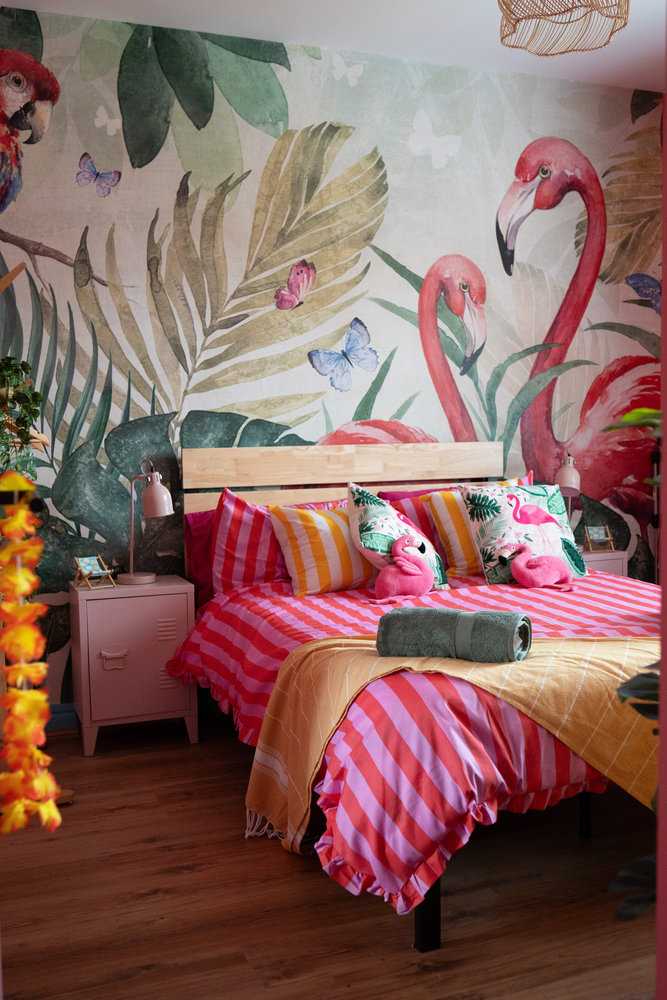 Flamingo-themed bedroom at Spangles Beach with tropical mural and pink striped bedding